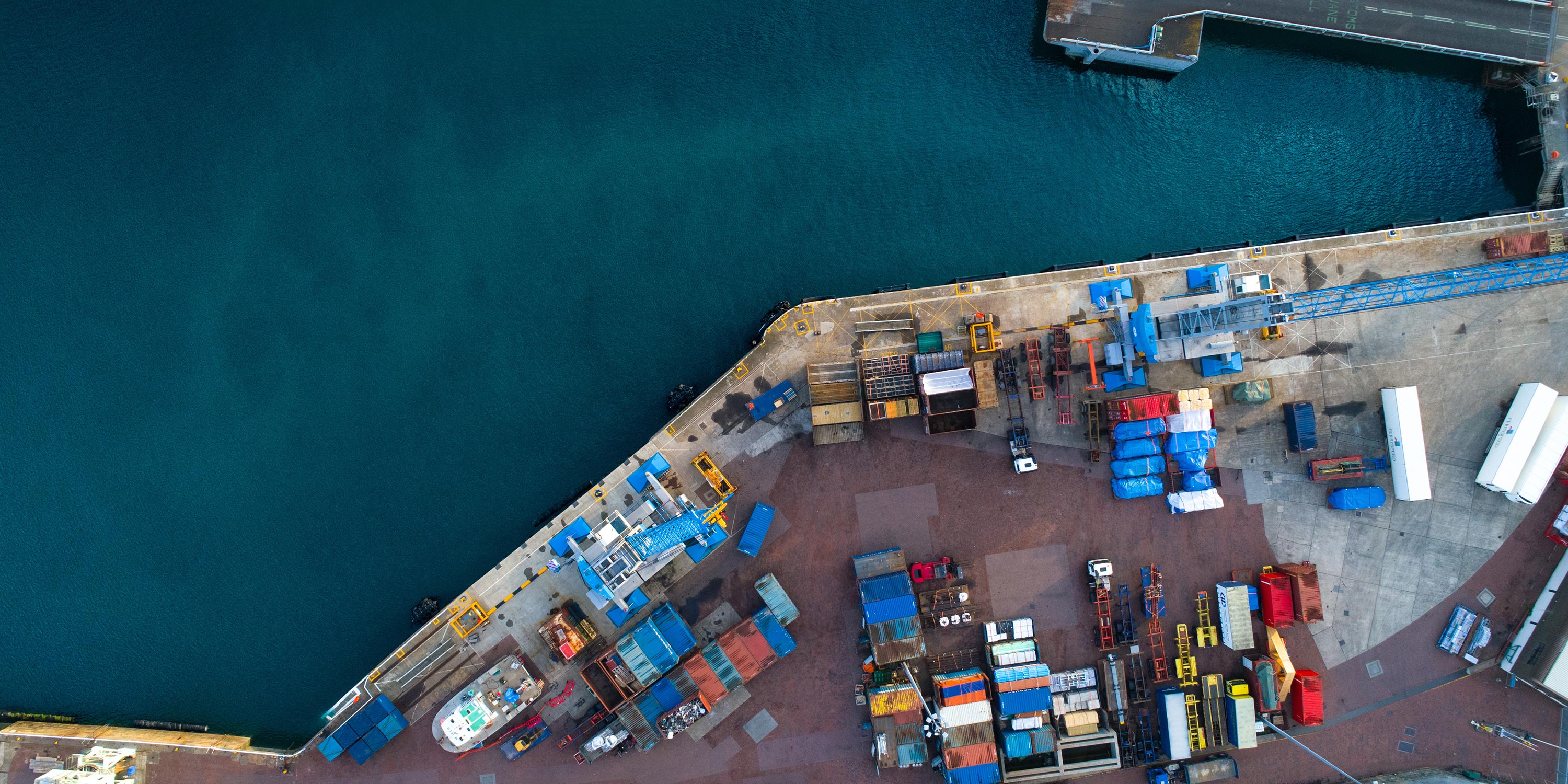 Aerial view of water and dock covered in shipping containers