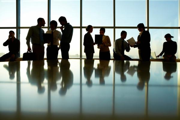 Business meeting in brightly lit glassed conference room